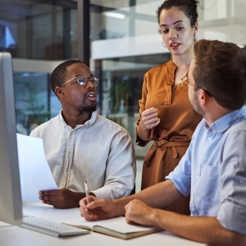 a man and woman sitting at a desk with a laptop