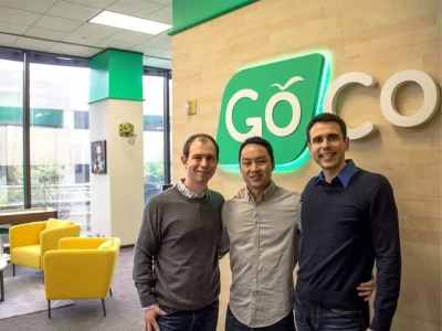 two men standing in front of a green sign