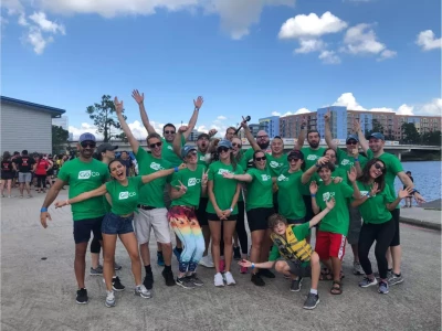 a group of people in green shirts posing for a photo
