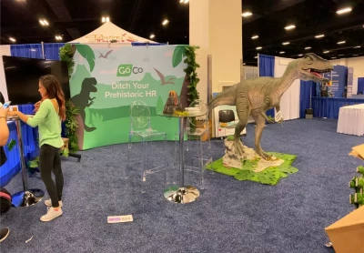 a woman standing next to a dinosaur