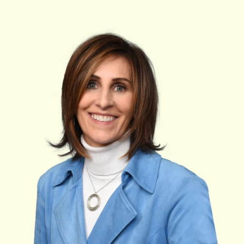 a woman in a blue jacket and white turtle neck sweater