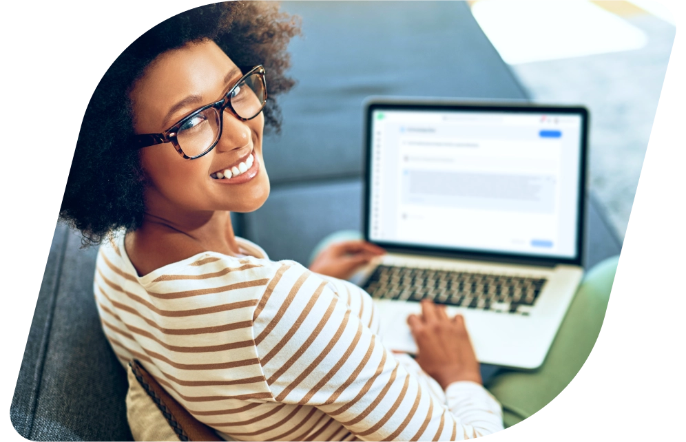 a young girl sitting on a couch using a laptop