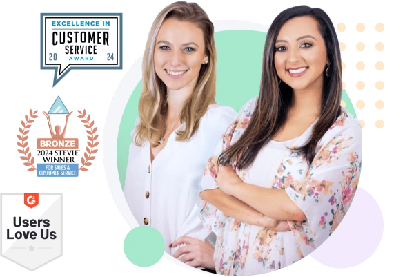 two women smiling and one is holding a phone