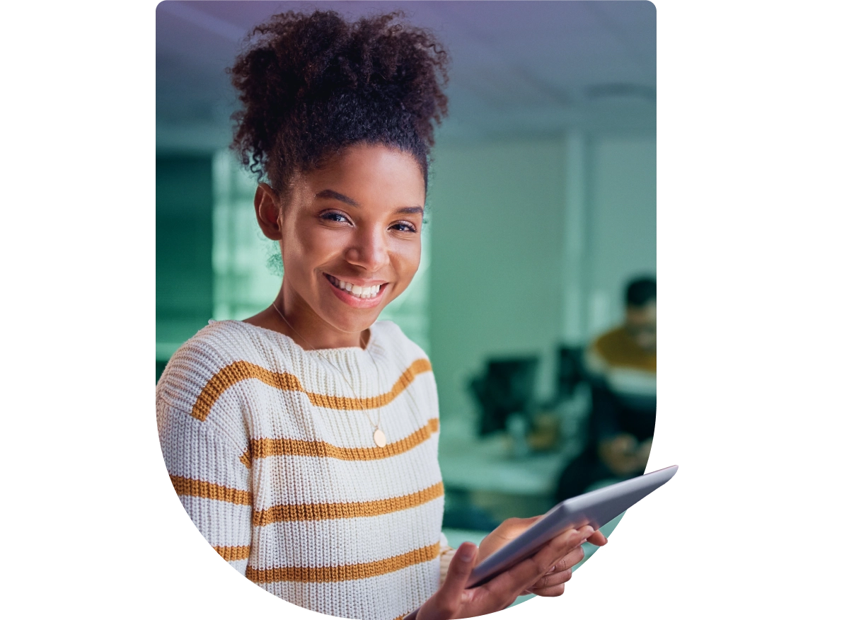 a young girl smiles while holding a tablet
