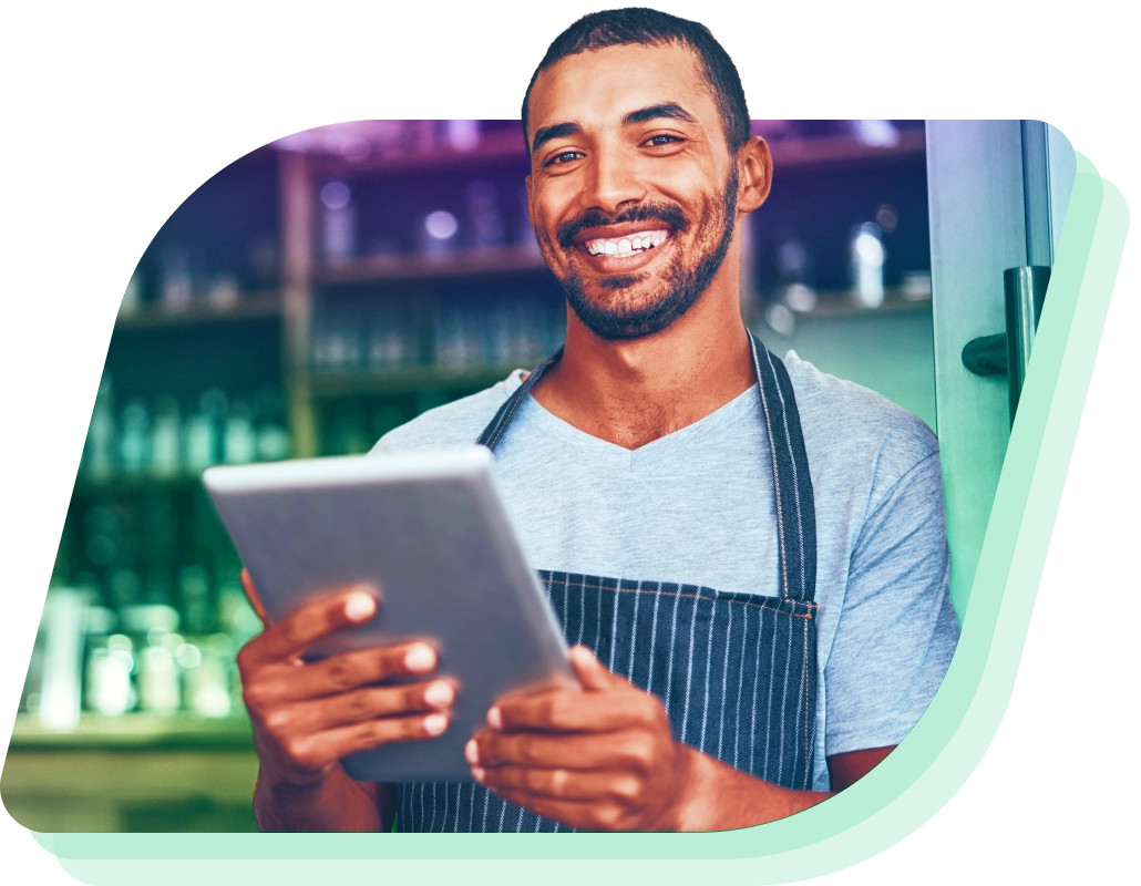 a man in an apron using a tablet