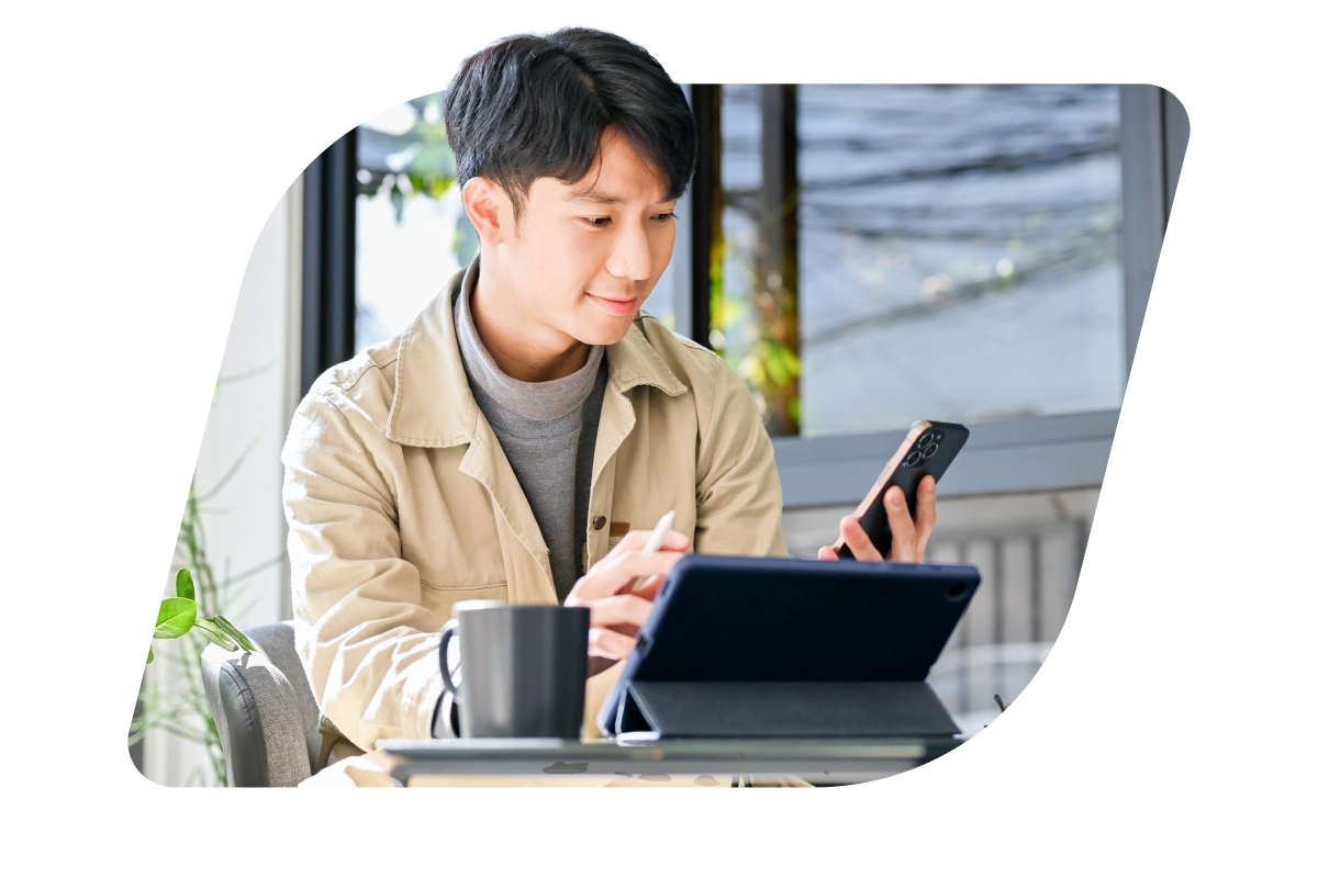 a man sitting at a table using a tablet