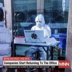 a man in a white suit sitting at a desk