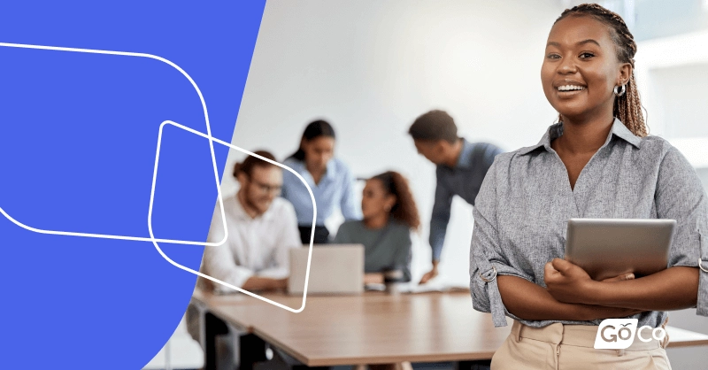 a woman standing in front of a laptop with a blue background
