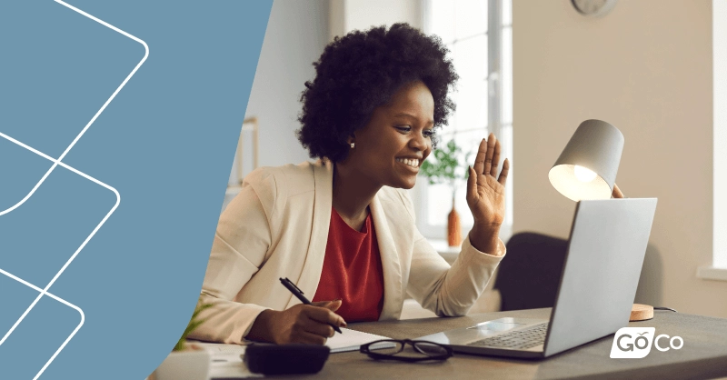 a woman sitting at a desk with a laptop and a laptop