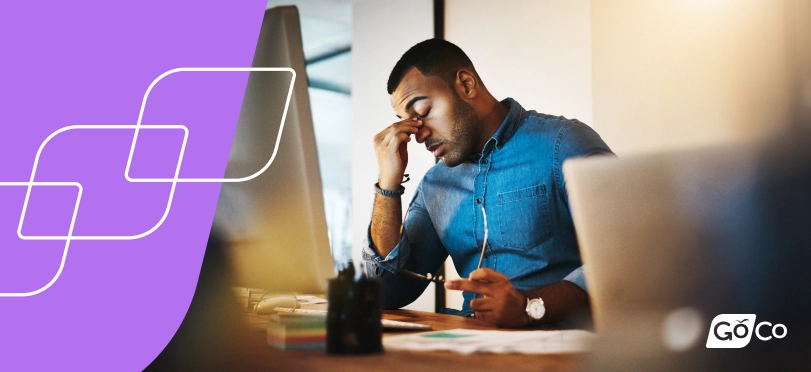 a man sitting at a desk with a laptop and a phone