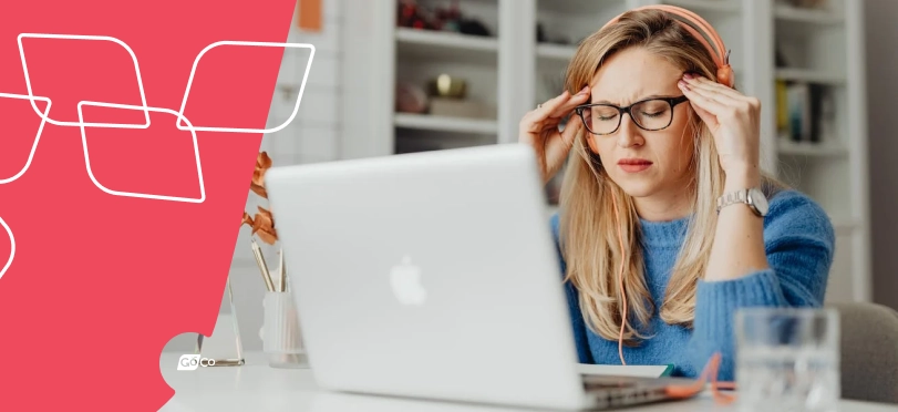 a woman sitting at a desk with a laptop and glasses