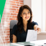 a woman sitting at a desk with a green background