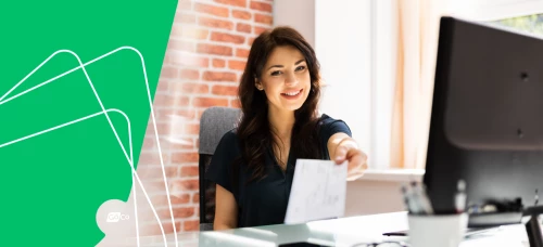 a woman sitting at a desk with a green background