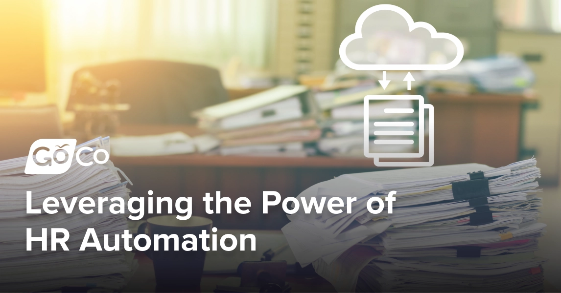 A desk with multiple stacks of paperwork sitting on it, with an icon floating above the desk showing papers pointing to a cloud.