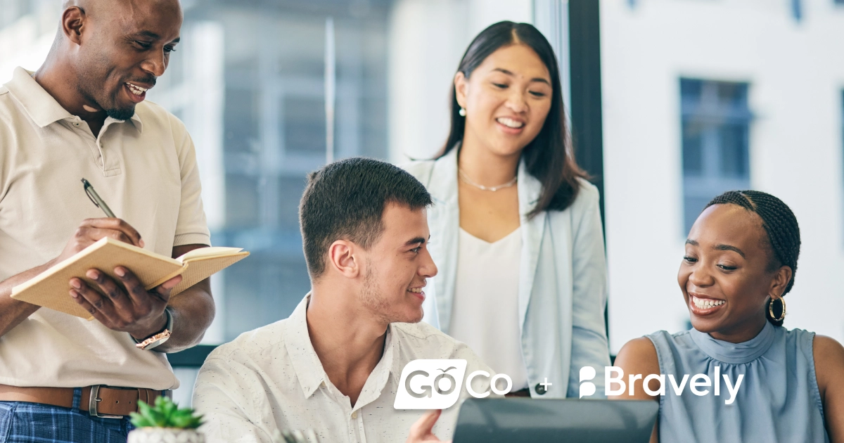 a group of people sitting around a table with a laptop