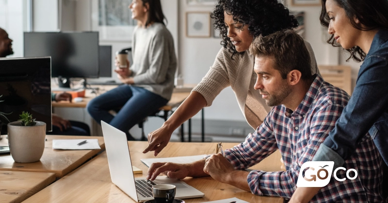 a group of people working on laptops in an office