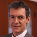 a man in a suit and tie standing in front of a door