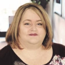 a woman sitting at a table with a laptop