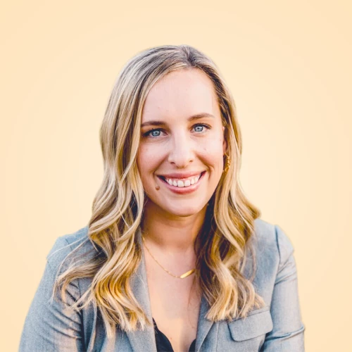 a woman with blonde hair and blue eyes smiles at the camera